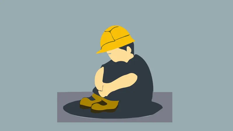 A construction worker sitting on the ground after a work injury