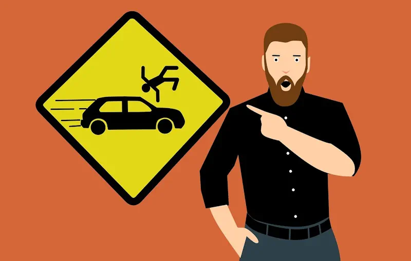 A man pointing at a sign warning about car accident injuries