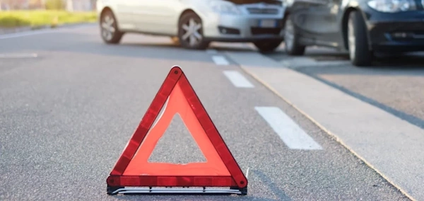 A red warning sign on the road at the scene of a car accident