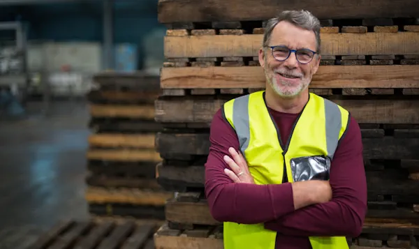 A smiling male worker in a safe work environment, illustrating the employer's responsibility to provide a safe work environment