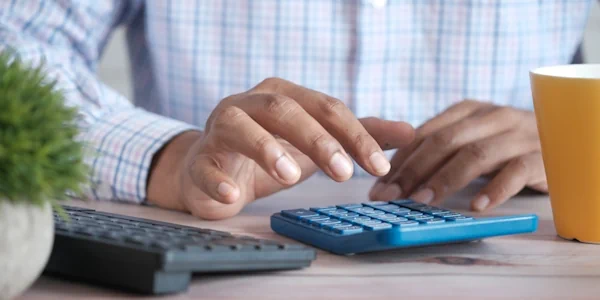 A man using a calculator to calculate the compensation for a personal injury case