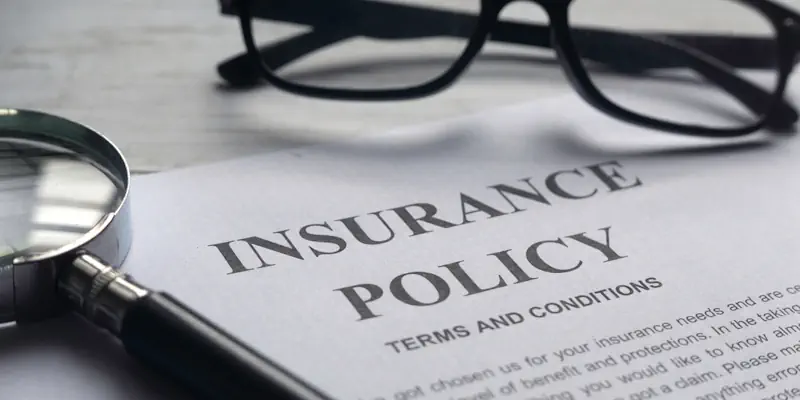Insurance policy terms and condition document lying on a desk with a magnifying glass on top