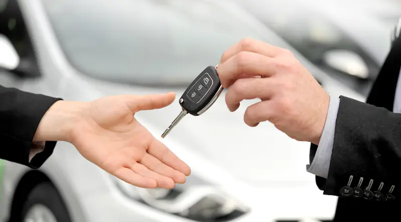A person receiving the key to a hire car after a car crash