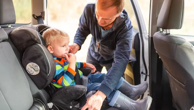 A man considering child height for booster seat in a motor vehicle