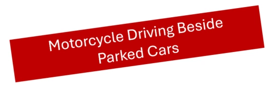 Motorcycle driving beside parked cars