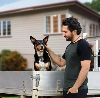 A man with dog in a ute after a successful compensation claim